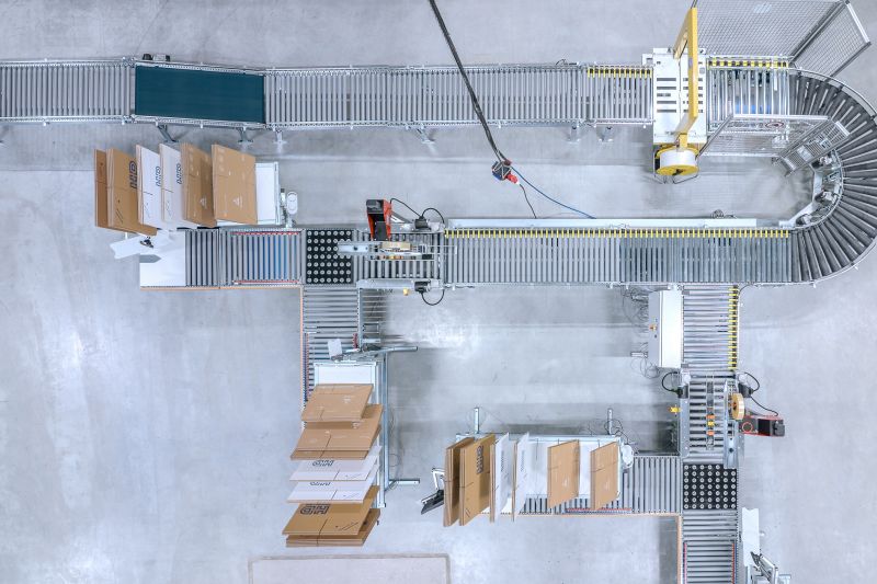 Umreifungsmaschine in Verpackungslinie integriert Umreifungsmaschine in Verpackungslinie integriert