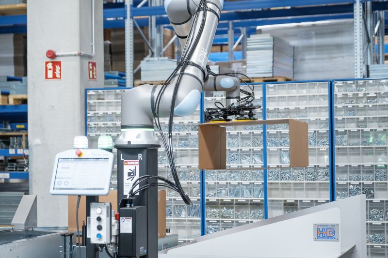 Cobot richtet Kartons auf