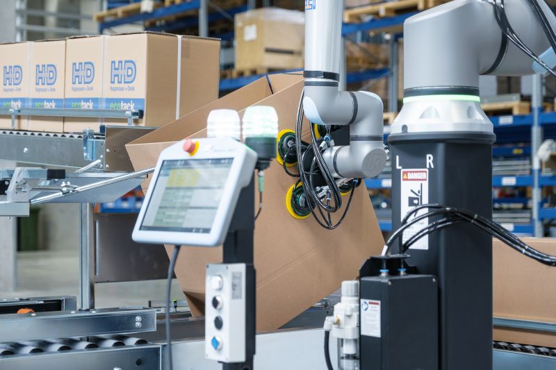 Ein kollaborativer Roboter richtet Kartons auf